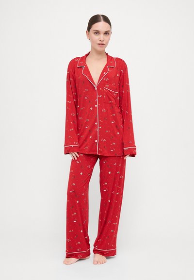 Conjunto de pijama vermelho com uma camisola de manga longa com botões e calças largas, adornado com pequenos padrões florais e detalhes em branco.