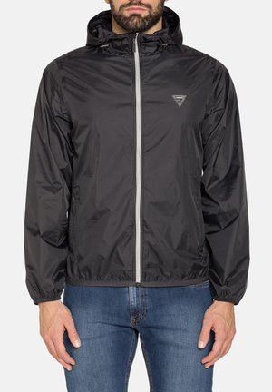 Giacca leggera nera con cappuccio, zip frontale, polsini elastici e patch con logo. Tessuto liscio e materiale resistente al vento.