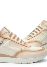 Zapatillas altas de cuero beige con cordones elásticos, puntera redonda, acentos más claros contrastantes y suela texturizada. Logo de la marca en el lateral.