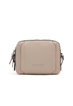 Sac à bandoulière rectangulaire en cuir beige avec logo à l'avant, fermetures éclair sur les côtés et bandoulière réglable.