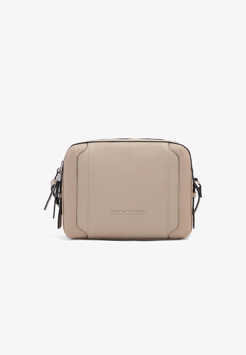 Sac à bandoulière rectangulaire en cuir beige avec logo à l'avant, fermetures éclair sur les côtés et bandoulière réglable.