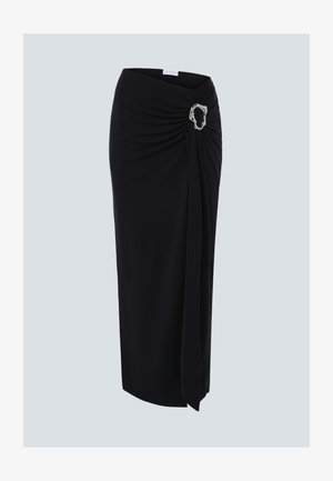 Jupe midi noire avec détail drapé à l'avant et boucle ovale argentée sur la hanche droite, sur fond uni.