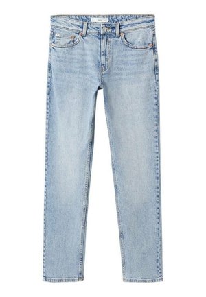 Person iført sort læderblazer, hvid t-shirt, lyseblå jeans med sort bælte og sorte ankelstøvler, stående mod en ensfarvet baggrund.