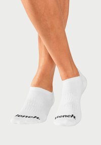 White ankle socks made of soft cotton blend, featuring ribbed texture and black "Bench." logo on the side.