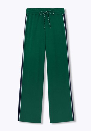 Pantalon de survêtement vert à jambes larges avec des panneaux latéraux bleu marine et un liseré blanc, taille élastique avec cordon noir et blanc.