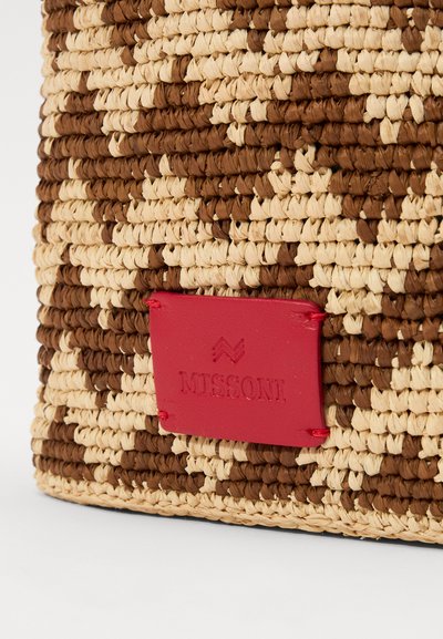 Woven straw bag featuring a chevron pattern in brown and beige, with a red leather label embossed with "MISSONI." Square shape, textured surface.