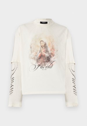 Chemise blanche à manches longues avec manches superposées, présentant une illustration d'une femme en prière et le texte "Favela" sur le devant et la manche.