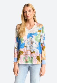 Bluse mit floralem Muster, V-Ausschnitt, langen Ärmeln und hellblauen Manschetten. Enthält große Blumen in Blau-, Grün-, Rosa- und Brauntönen.