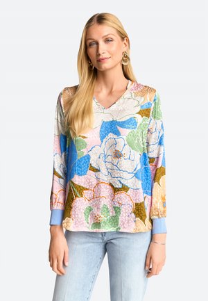 Bluse mit floralem Muster, V-Ausschnitt, langen Ärmeln und hellblauen Manschetten. Enthält große Blumen in Blau-, Grün-, Rosa- und Brauntönen.