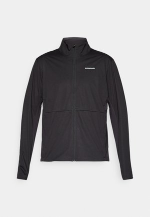 Jachetă neagră Patagonia cu fermoar, mâneci lungi și guler înalt, expusă plat pe un fundal alb.