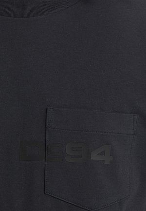 Schwarzes Baumwoll-T-Shirt mit Rundhalsausschnitt, kurzen Ärmeln und einer linken Brusttasche. Auf der Vorderseite prangt ein erhabenes schwarzes Grafikdesign "DC94".