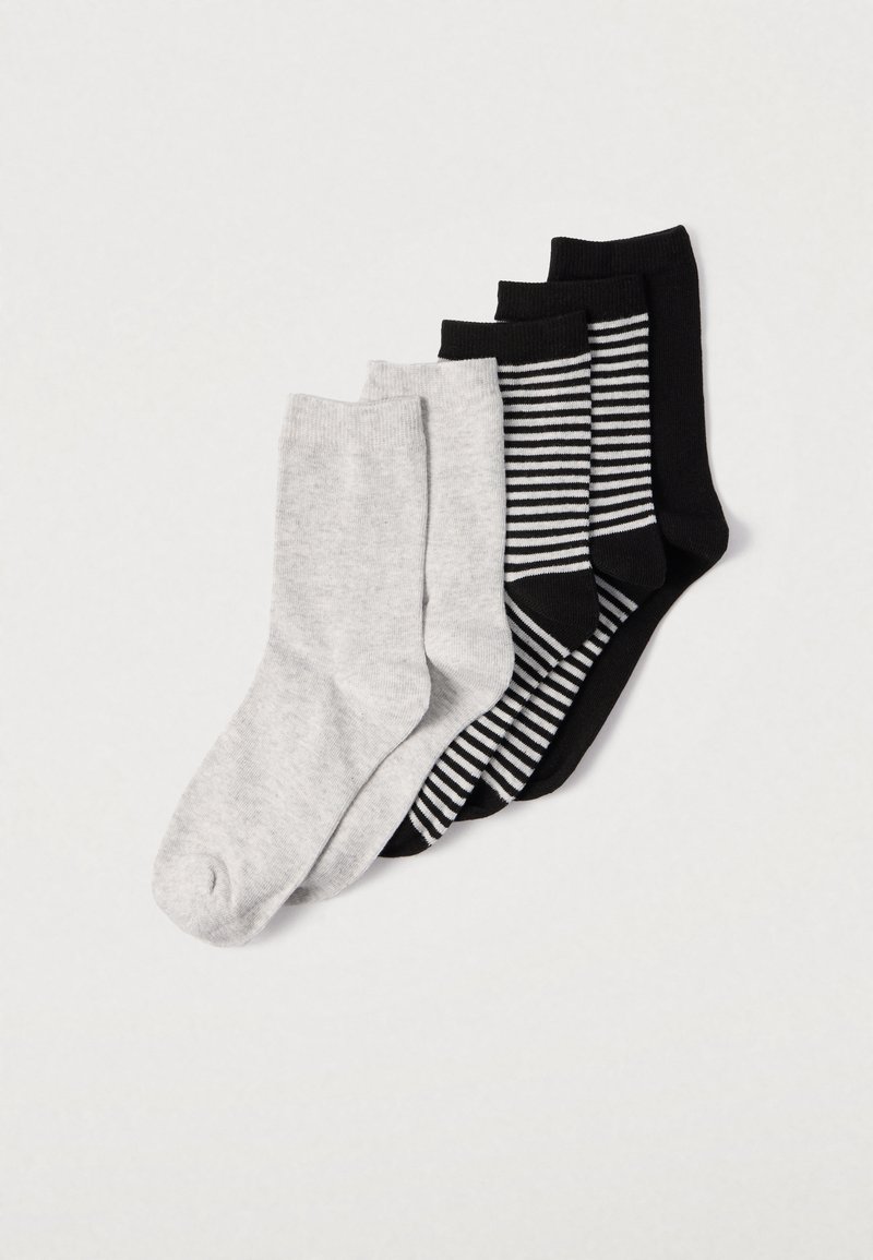 Quatre paires de chaussettes : une gris clair, deux noires unies et une noire à rayures blanches. Matières en maille douce, longueurs variées.