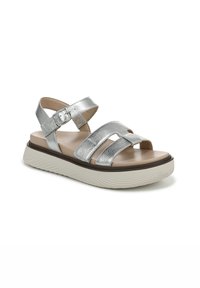 Sandal in metallo argento con tre fasce larghe, apertura frontale e suola piattaforma marrone. Chiusura con fibbia sulla cinghia alla caviglia.