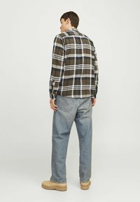 Geruit flanellen overhemd in olijf, wit en marineblauw, met lange mouwen en een klassieke kraag. Draag het met losse, lichtblauwe jeans en beige schoenen.