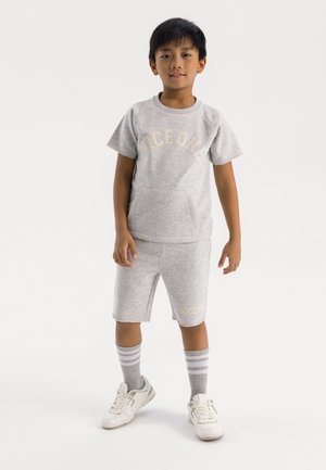 T-shirt en coton gris pour jeunes avec l'imprimé "NICE ONE", associé à un short assorti. Des baskets blanches et des chaussettes rayées grises complètent la tenue décontractée.