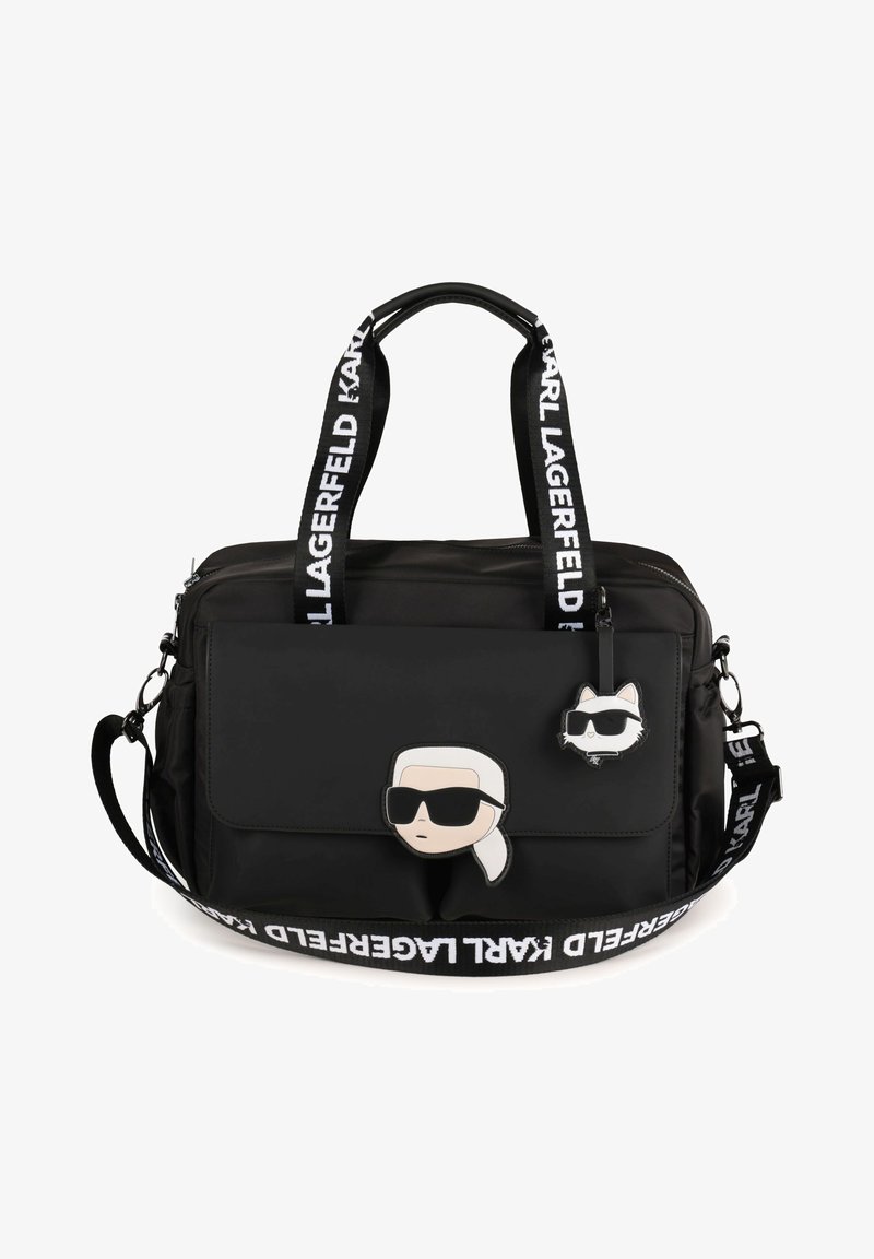 Melnā neilona soma ar divām rokturiem, logotipa siksnām, priekšējo kabatu un karikatūru varoņu akcentiem. Ietver atdalāmu rotājumu un elegantu dizainu.