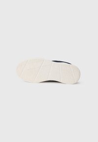 Tenis navy cu o talpă din cauciuc alb. Talpa prezintă un model geometric texturat pentru aderență și durabilitate, având un design superior neted.