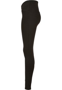 Leggings noirs avec une taille haute, fabriqués en tissu extensible en coton mélangé, présentant une texture lisse et un design ajusté.