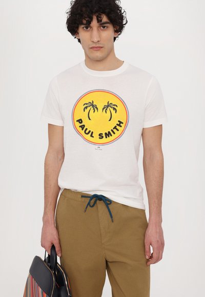 White cotton t-shirt with a round, colorful palm tree logo; paired with khaki pants featuring a blue drawstring.