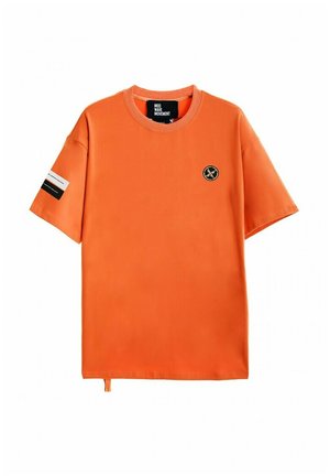 Camiseta de manga corta naranja hecha de una tela suave, con cuello redondo, pequeño logotipo en el pecho y una etiqueta en contraste en la manga.