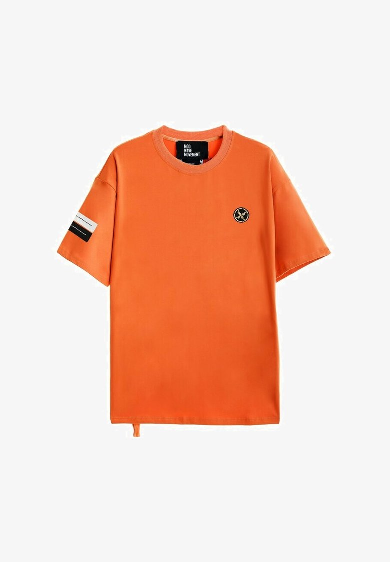 Camiseta de manga corta naranja hecha de una tela suave, con cuello redondo, pequeño logotipo en el pecho y una etiqueta en contraste en la manga.