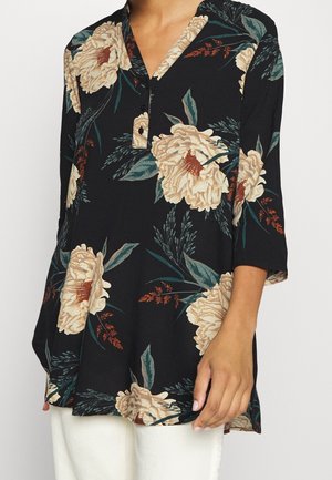 Top met bloemenprint op een zwarte achtergrond, met beige pioenrozen en groene bladeren. Ontworpen met een kraag en driekwart mouwen.