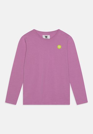 Chemise lavande à manches longues avec col rond et petit logo circulaire jaune sur la partie supérieure gauche de la poitrine.