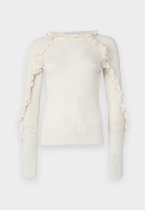 Ribbed, cream-colored sweater with ruffle details along the shoulders and down the sleeves. Fitted design and long sleeves. Smooth texture.