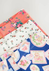 Campioni di tessuto di cotone in varie stampe floreali e grafiche: corallo con fiori, bianco con piccole rose, blu con toppe decorative.