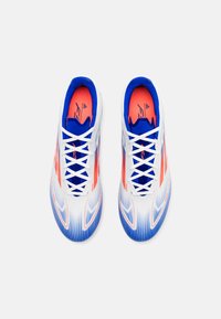 Scarpe sportive bianche con dettagli blu e corallo, caratterizzate da un design elegante, una parte superiore testurizzata e un tradizionale sistema di allacciatura.