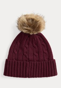 Burgundy knitted beanie with a ribbed brim and cable pattern, topped with a large beige faux fur pompom.
