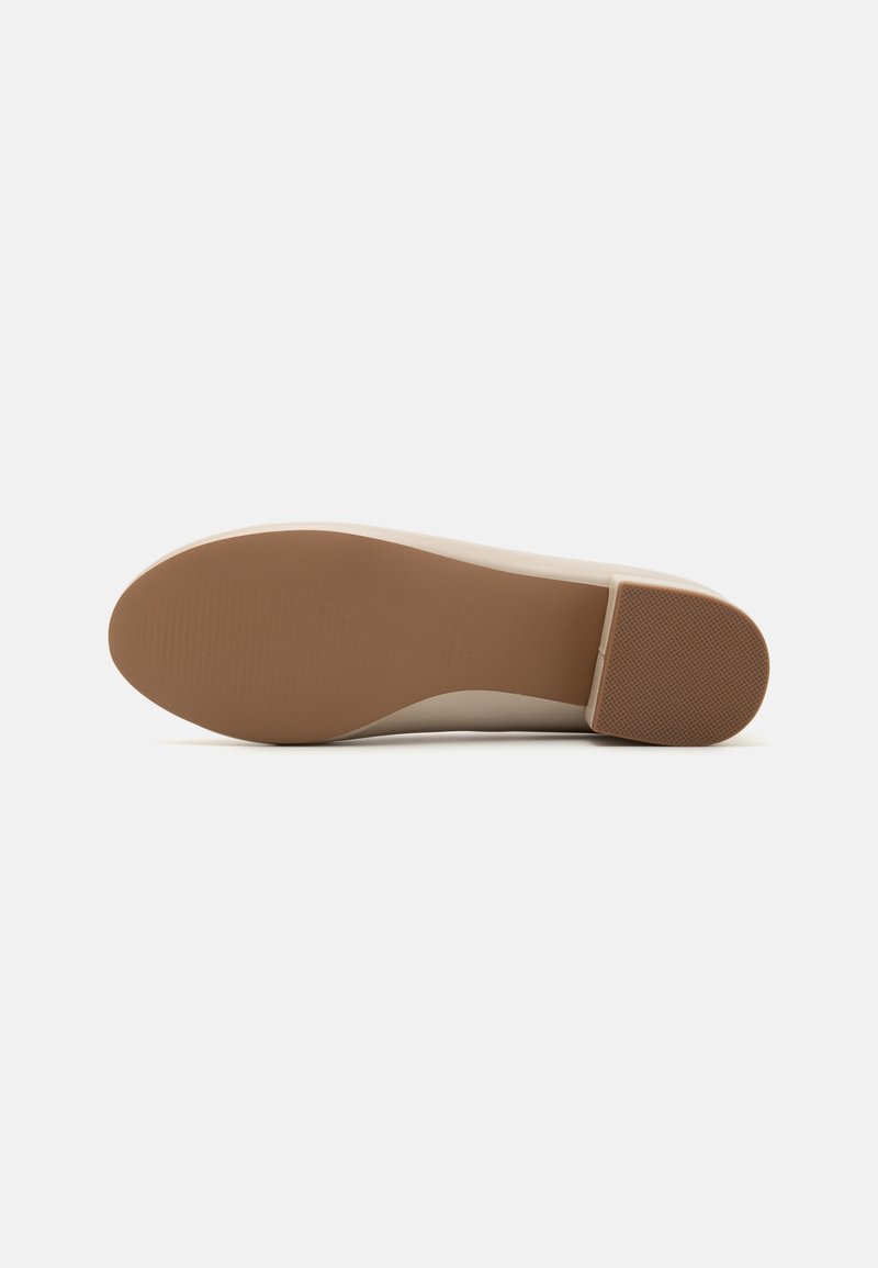 Semelle de chaussure synthétique beige avec une surface lisse et une légère texture, présentant une forme arrondie et un petit talon à l'arrière.