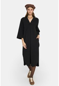 Czarna sukienka do kolan z dekoltem w serek, rękawami o długości trzech ćwiartek i kieszeniami po bokach. Gładka faktura, luźny krój, z rozcięciami po bokach.