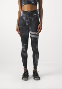 Černé a šedé legíny s efektom tie-dye a vysokým pasem, s akcenty stříbrné síťoviny na levém stehně a pružným materiálem.