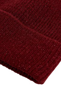 Gorro de punto burdeos con una textura acanalada y acentos de hilo metálico, creando un sutil brillo en contraste con la suave tela.