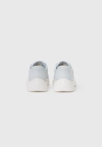 Baskets de sport bleu clair avec une tige en mesh texturé et une semelle en caoutchouc blanc, dotées d'un design profil bas et d'un dos rembourré pour le confort.