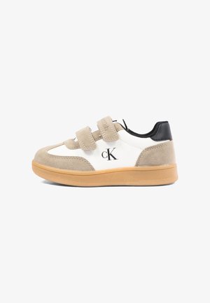 Niskie dziecięce sneakersy w beżu i bieli z czarnym obcasem, dwoma beżowymi paskami na rzep oraz gumową podeszwą z logo Calvin Klein.