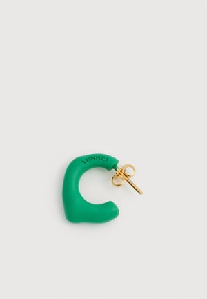 Groen oorbel in de vorm van een halve maan met gouden steker en vlinderachterkant, gegraveerd met het woord "SUNNEI" op een witte achtergrond.