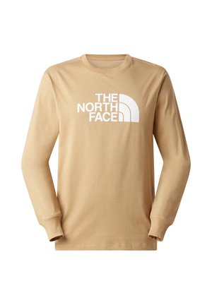 Beige langärmeliges T-Shirt aus Baumwolle mit Rundhalsausschnitt, das vorne ein großes weißes Logo von "THE NORTH FACE" zeigt.