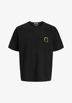 Czarna bawełniana koszulka z okrągłym dekoltem, z małą żółtą grafiką. Połączona z jasnymi dżinsowymi szortami i białymi skarpetkami oraz czarnymi tenisówkami.