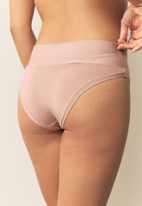 Svetloružové nohavičky s vysokým pásom, hladkým elastickým pásom a bezšvovými hranami. Mäkká tkanina s priliehavým strihom.