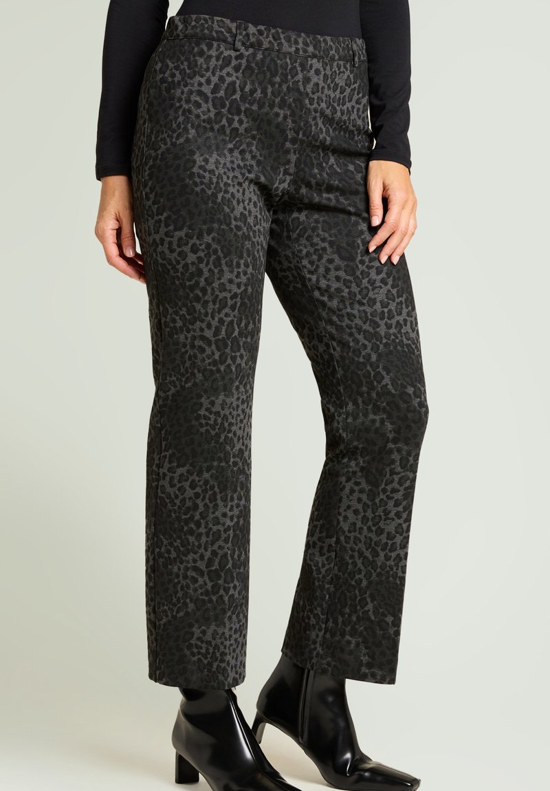 Pantalones con estampado de leopardo en gris oscuro con acabado texturizado, diseño de pierna recta y cintura de tiro medio. Combinados con botines negros.