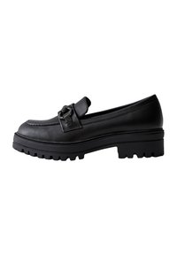Mocasines de cuero negro con suela gruesa y acanalada, que cuentan con una correa decorativa con detalle de herrajes en la parte frontal para un ajuste seguro.