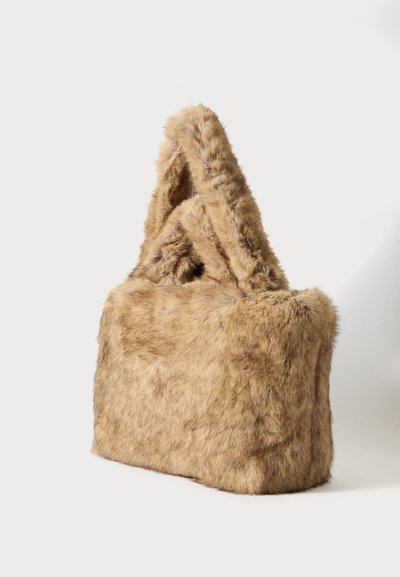 Brown faux fur tote bag, rectangular shape, soft texture, featuring two thick handles for carrying. No visible hardware or embellishments.