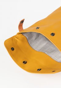 Gelbe wasserdichte Tasche mit glatter Oberfläche, ausgestattet mit schwarzem Zubehör und einem grauen karierten Innenfutter. Der Verschluss verwendet Druckknöpfe und Lederakzente.