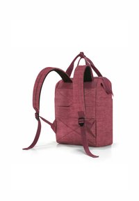 Mochila de tela burdeos con correas ajustables, forma rectangular, bolsillo frontal con cremallera y superficie texturizada. Presenta costuras reforzadas y un asa dual.