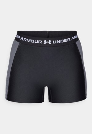 Crne atletske kratke hlače s širokim crnim pojasom na kojem piše "UNDER ARMOUR" bijelim slovima. Glatka tekstura s sivim bočnim panelima i uskim dizajnom.