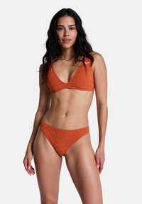 Ensemble bikini orange avec un motif en zigzag texturé, comprenant un haut bralette à col en V et un bas taille haute.