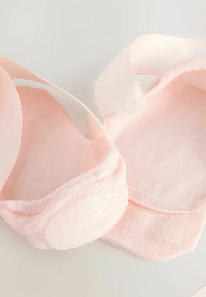 Světle růžové baletní ponožky vyrobené z pružného materiálu s plochými švy. Měkký materiál obepíná nohu a má hladkou podrážku s polstrováním.