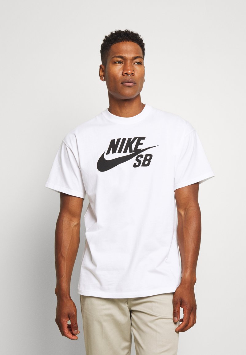 Vitt kortärmad t-shirt i bomull med en stor svart "NIKE SB" logotyp i en djärv design över framsidan.